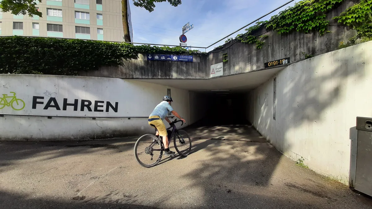 Beschilderung und Velofahrer im Bereich der Bahnhofunterführung in Dübendorf.